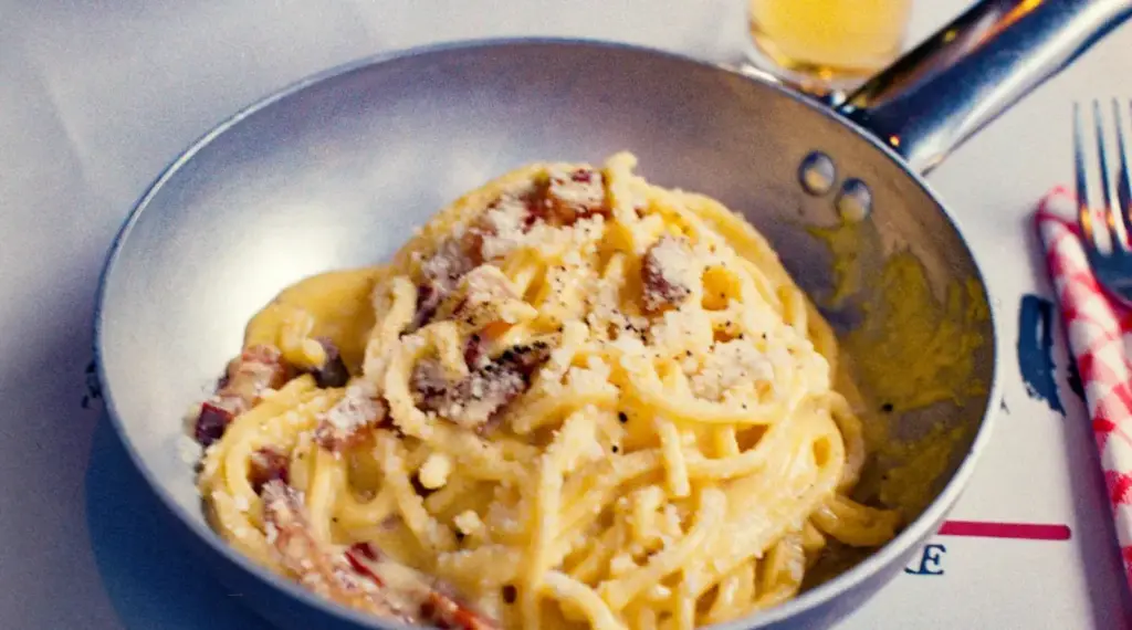 Spaghetti alla carbonara serviti in padella in un ristorante romano