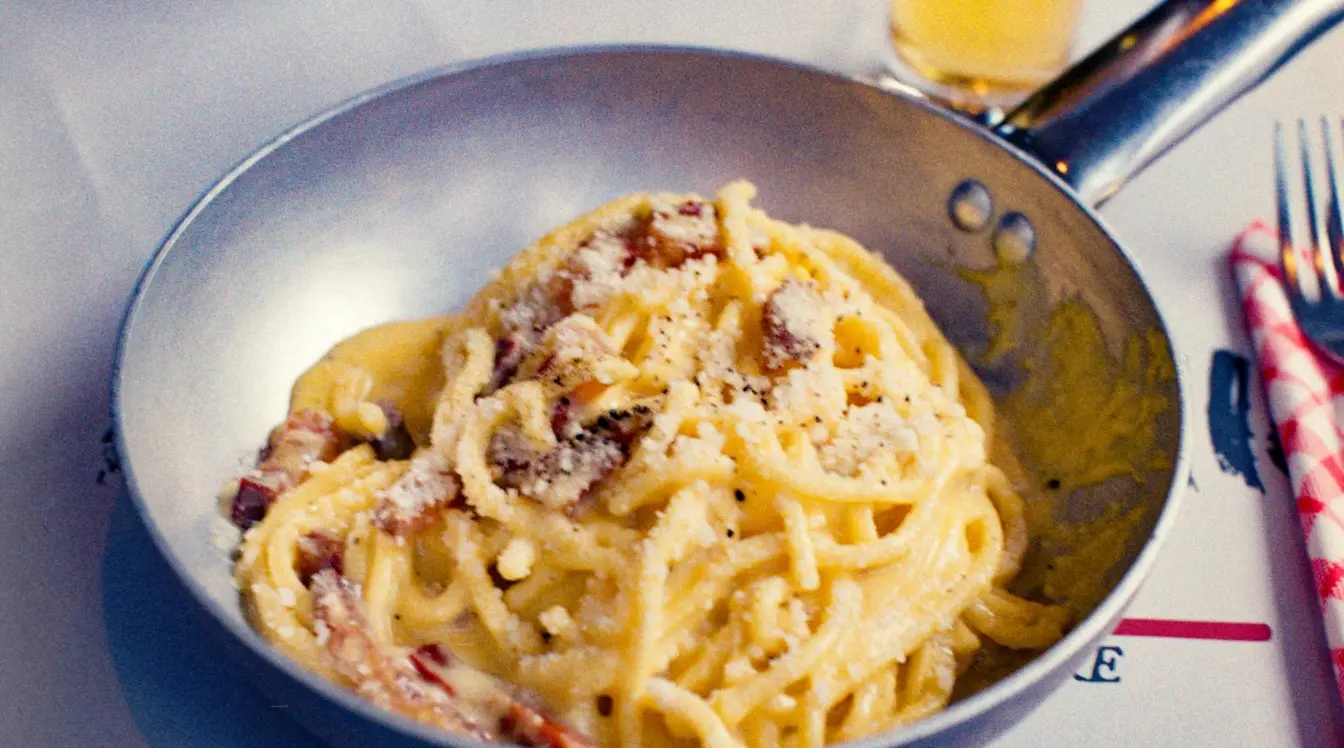 Spaghetti alla carbonara serviti in padella in un ristorante romano
