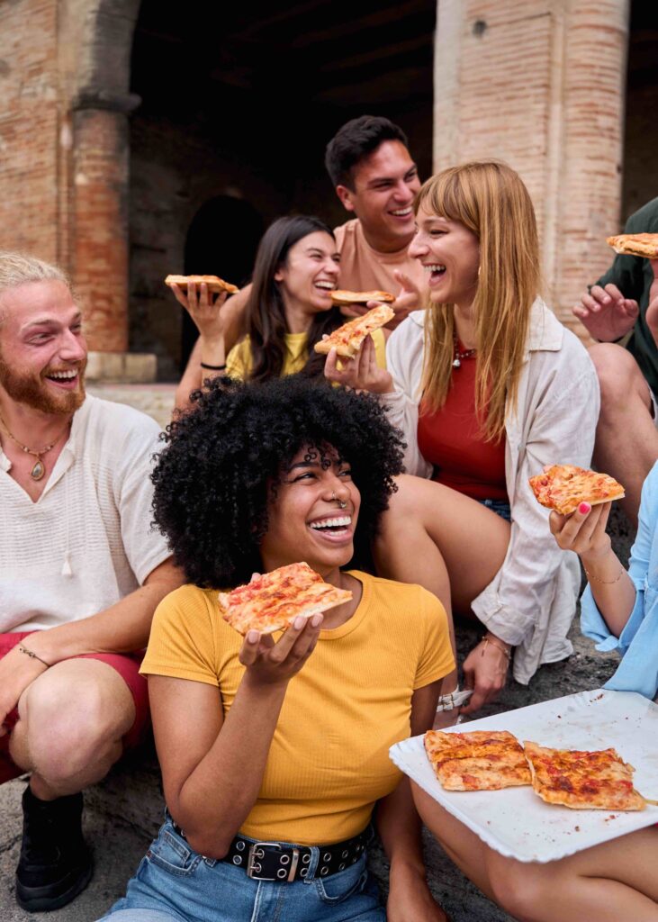 Amici con pizza durante una degustazione a Roma